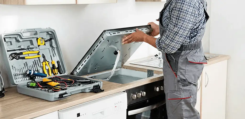 Handyman repairing a cooktop and checking wiring connections in Saint Petersburg, FL