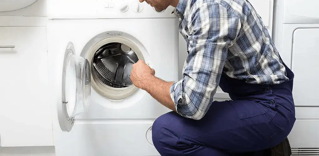 Handyman inspecting a dryer drum and internal parts for repair in Saint Petersburg, FL