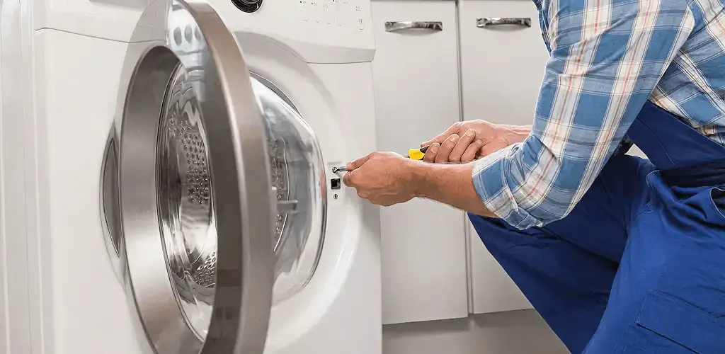 Handyman repairing a clothes dryer and checking electrical connections in Saint Petersburg, FL