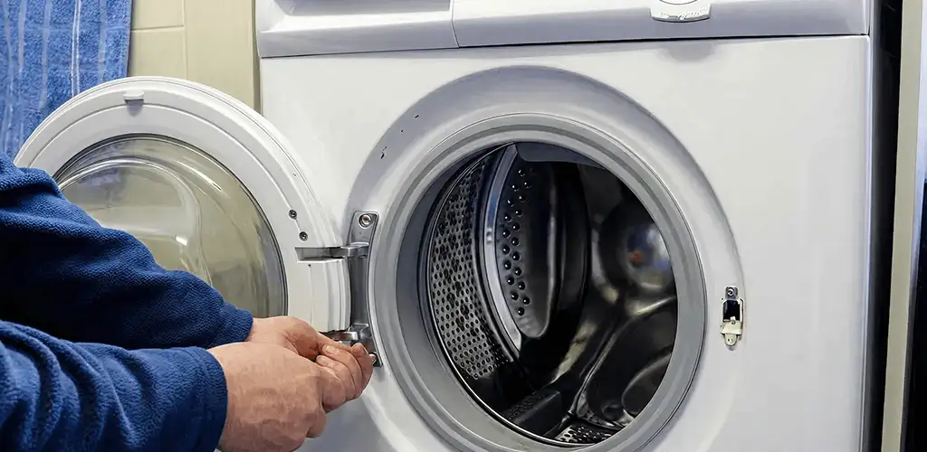 Washing machine repair handyman checking a front-load washer door and latch in Saint Petersburg, FL