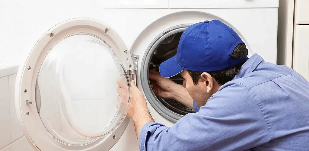 Washing machine repair handyman inspecting a front-load washer drum in Saint Petersburg, FL